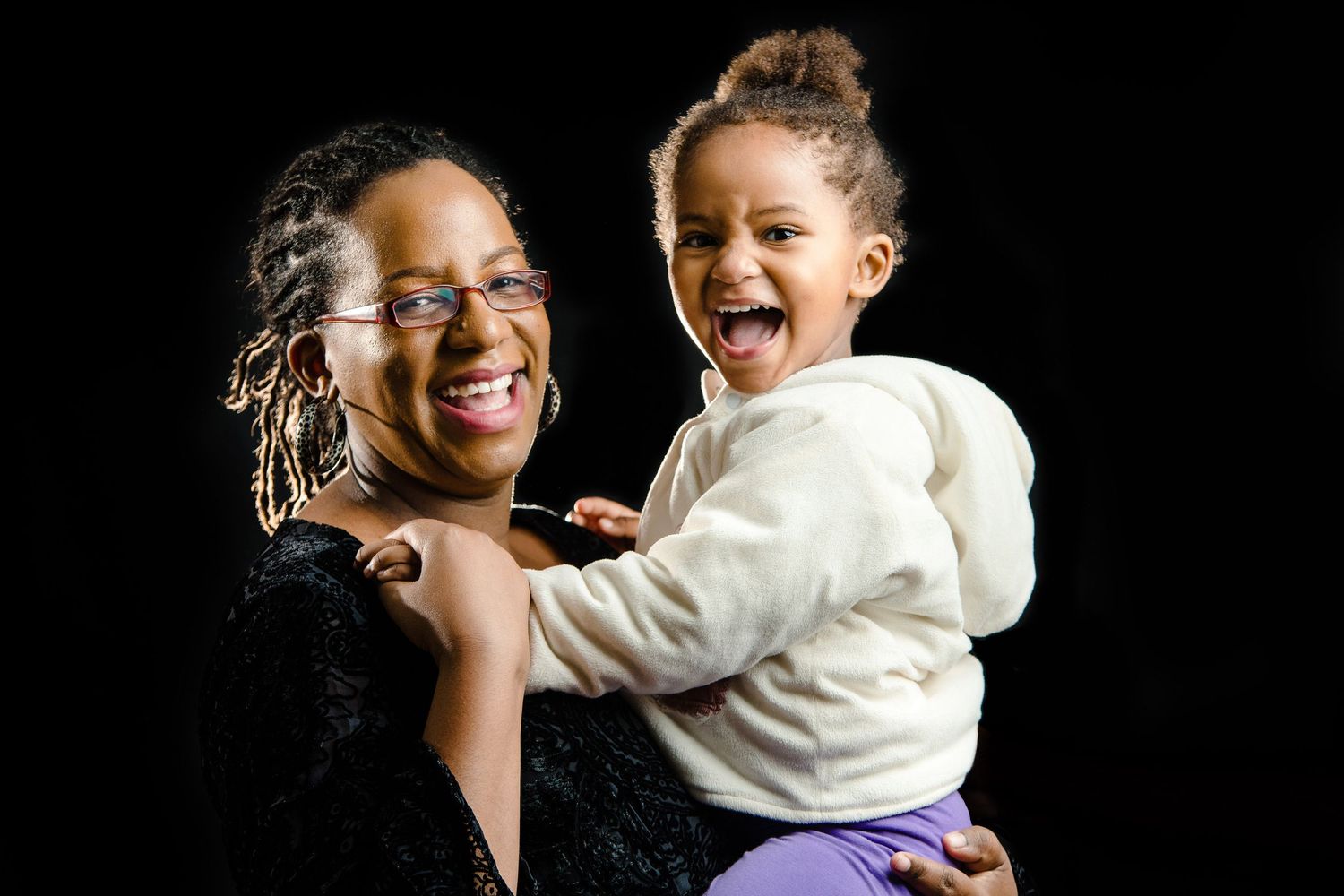 Candid moments of joy and laughter captured against black background in studio setting.
