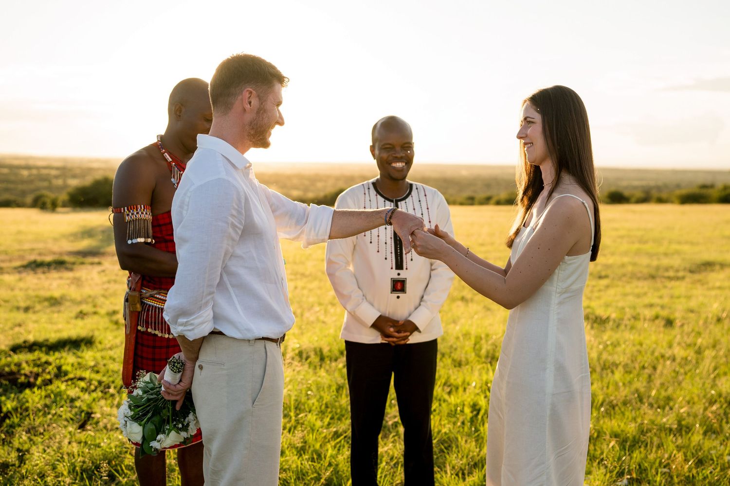 A celebratory outdoor wedding ceremony during sunset with traditional African elements.