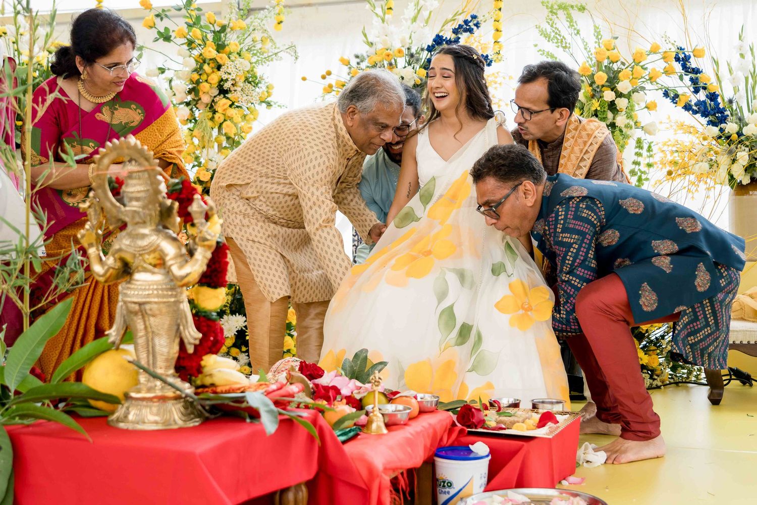 Group participating in a traditional ceremony with yellow flowers and decorative elements.
