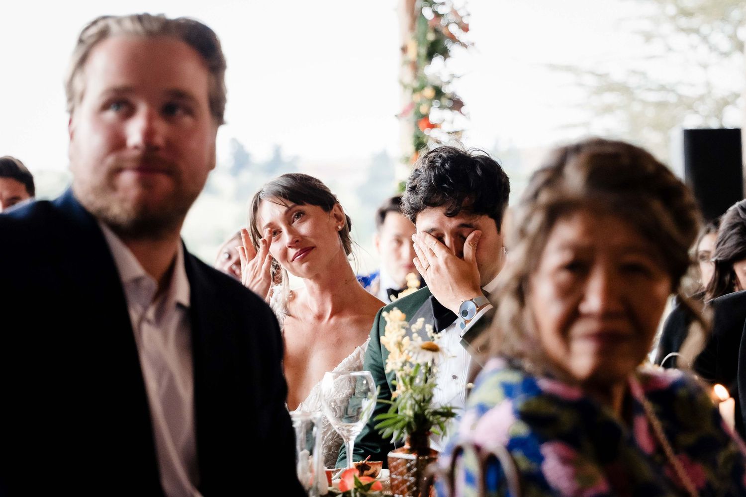 A collection of candid wedding celebration photos showing guests and decorative floral arrangements at an indoor venue.