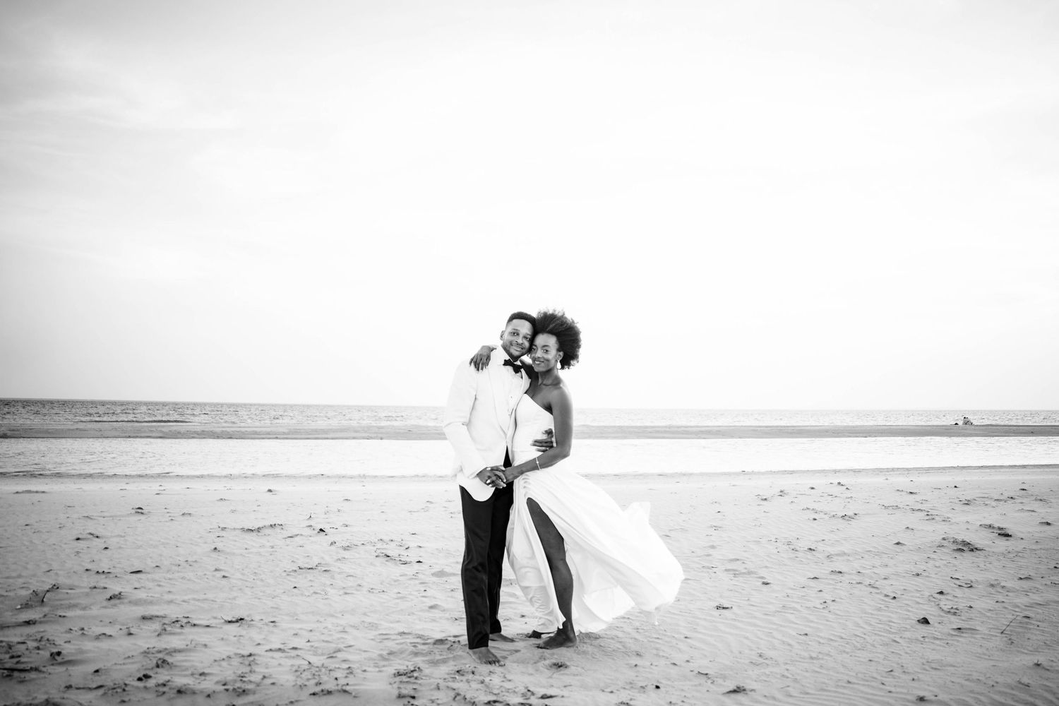 A series of romantic black and white beach wedding photos showing couples embracing on a sandy shoreline.