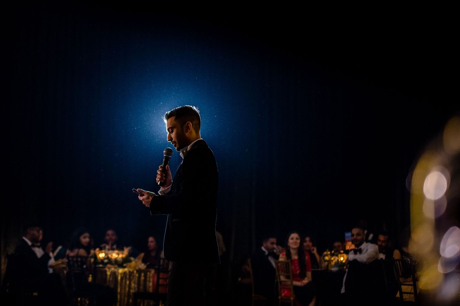 Moody nighttime event photography with dramatic blue backlighting and silhouettes.