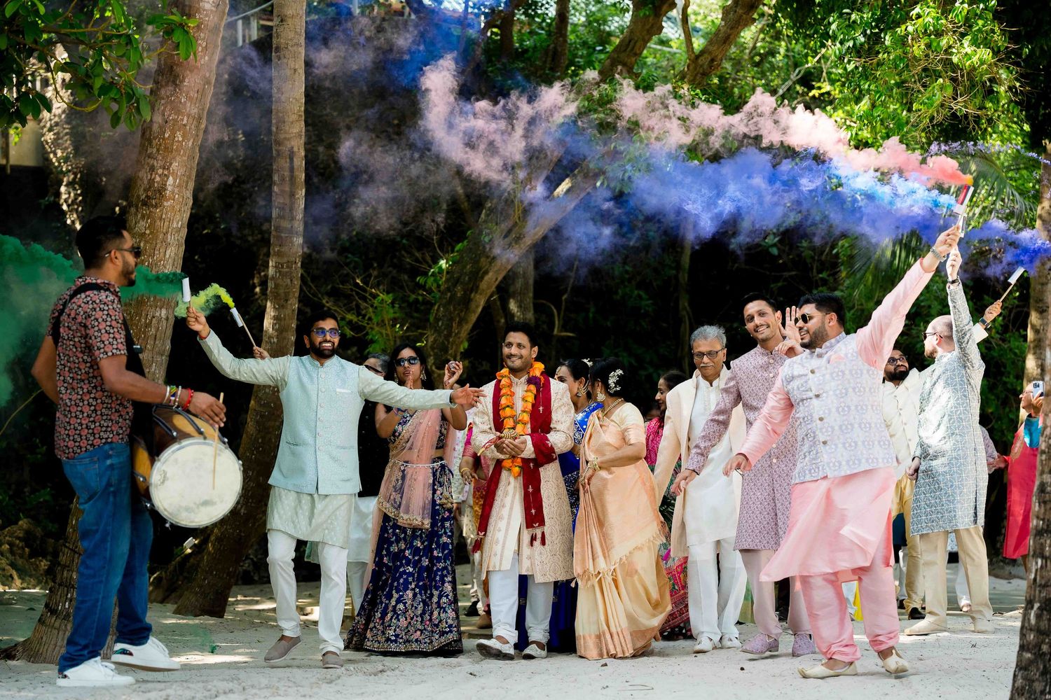 A group of people dancing in traditional Indian attire during a festive celebration outdoors.