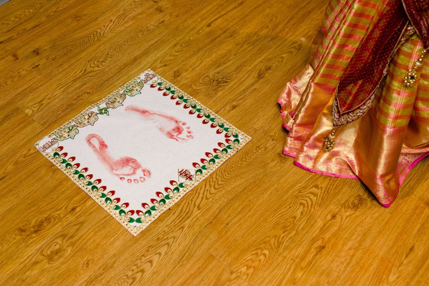 Wedding cards and decorative elements arranged on a wooden floor.