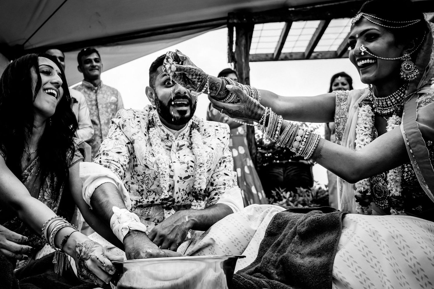 Black and white candid shots capturing joyful moments at a wedding celebration.