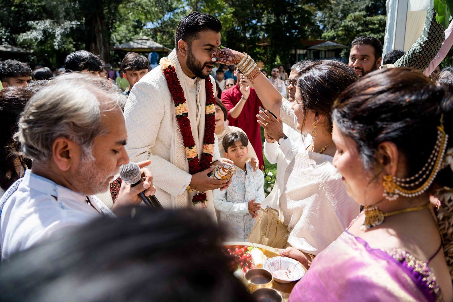 Traditional wedding ceremony rituals being performed under bright daylight.