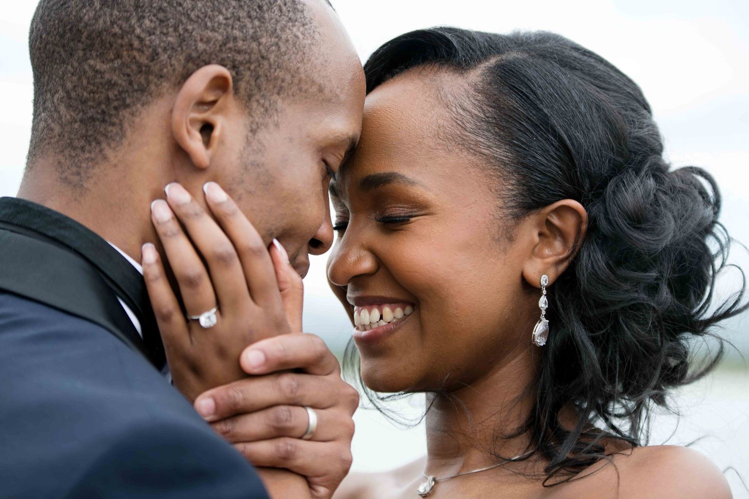 A tender close-up moment between newlyweds sharing joy and laughter.