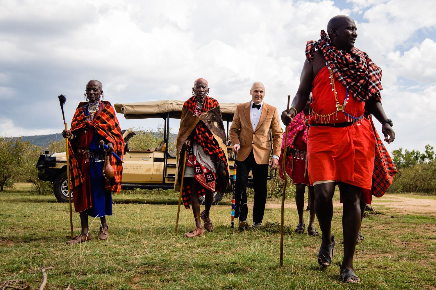 Traditional Maasai gathering in colorful red robes on African grasslands.