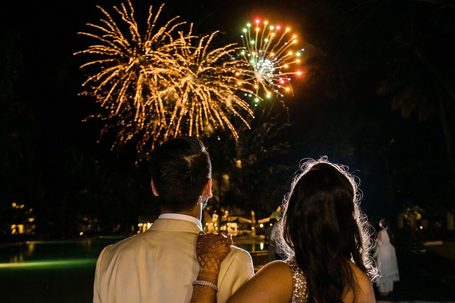 Golden fireworks bursting in the night sky during a celebration.