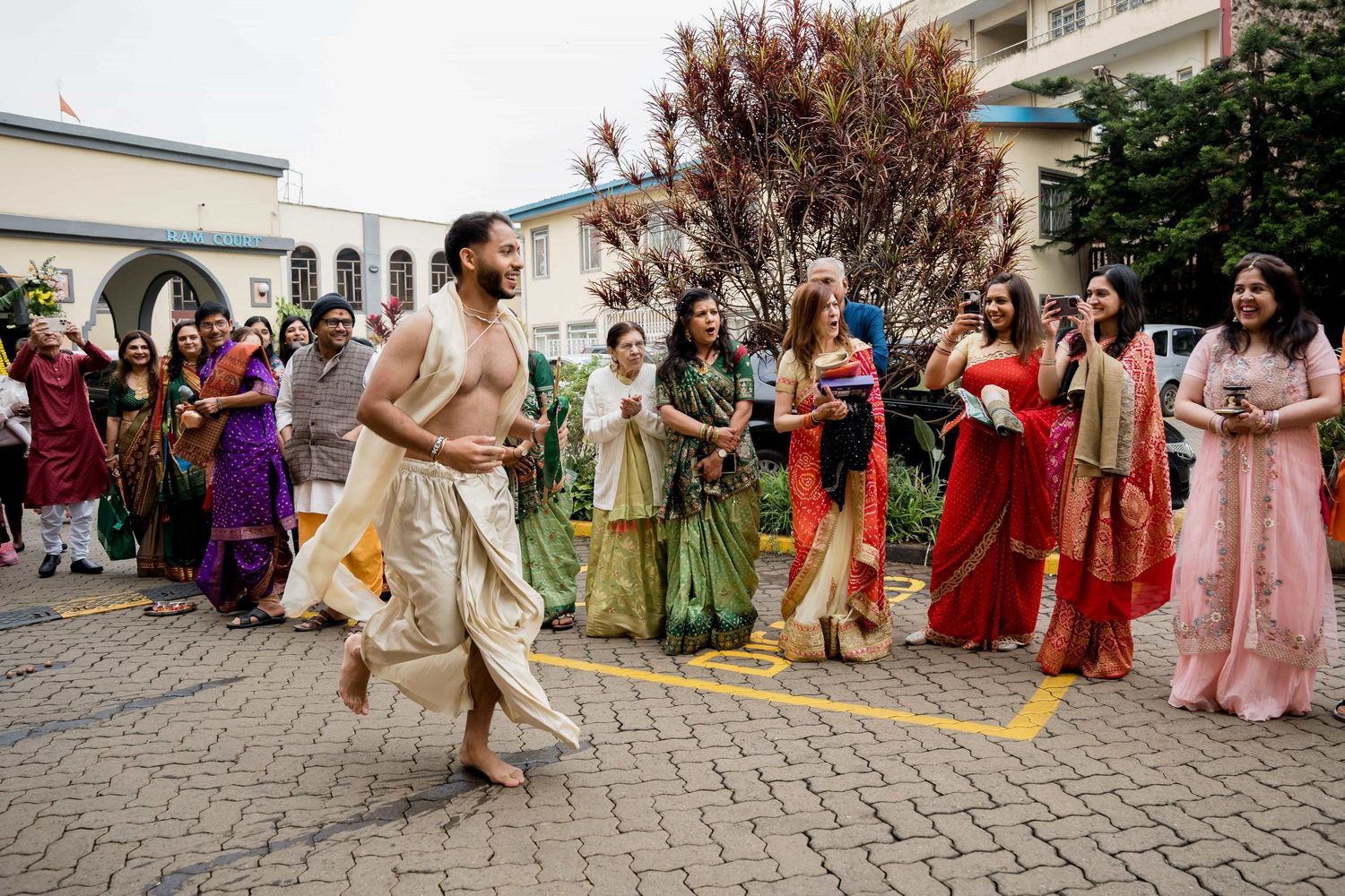 Traditional Indian dance performance at outdoor wedding celebration with guests watching.