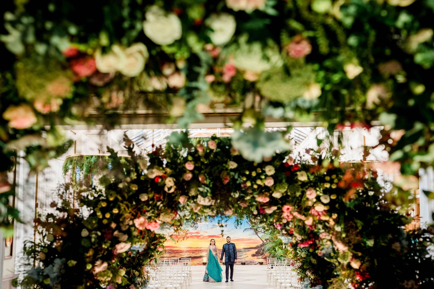 Romantic floral arch creates a tunnel of roses and blooms in a garden setting.