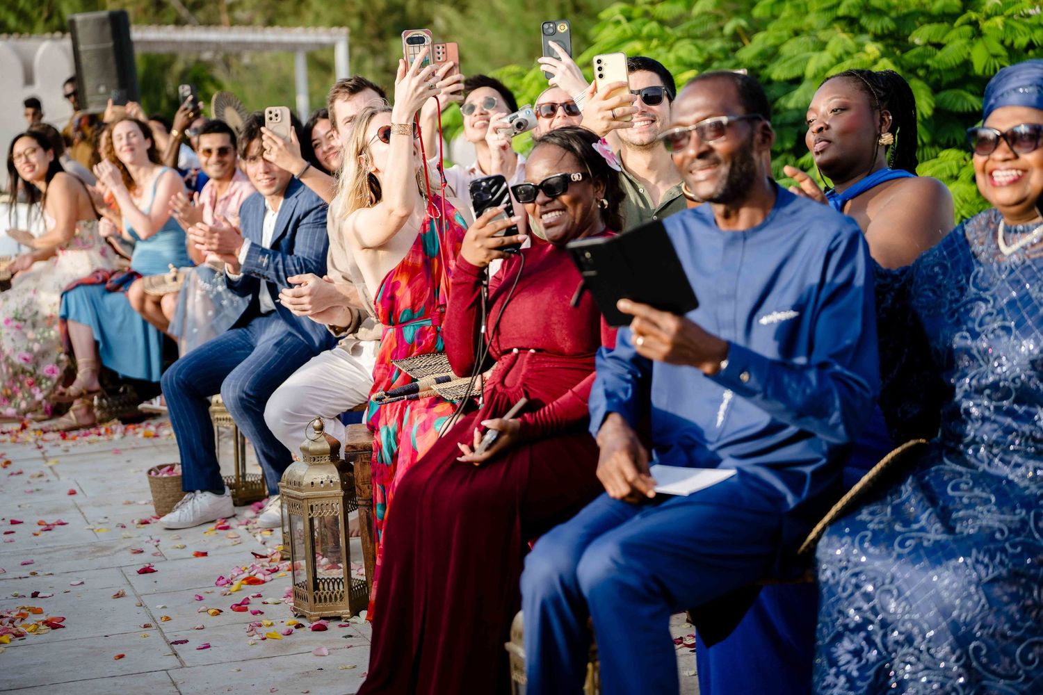 Wedding guests react with excitement and joy during an outdoor ceremony celebration.