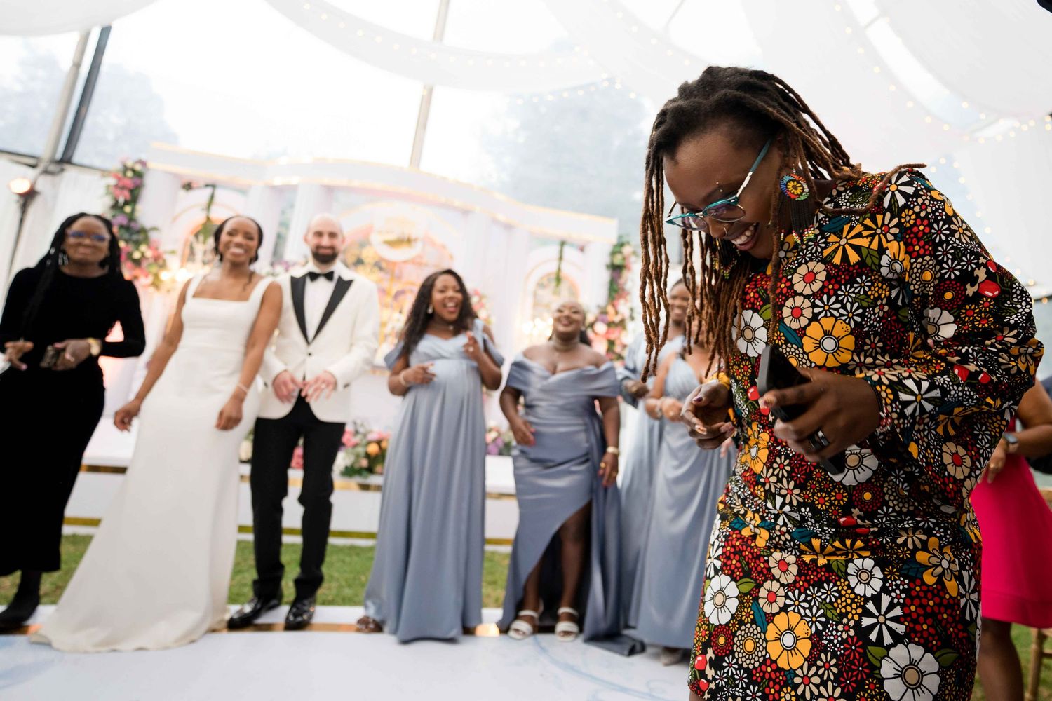 Wedding party dances and celebrates together on the dance floor at an indoor reception venue.