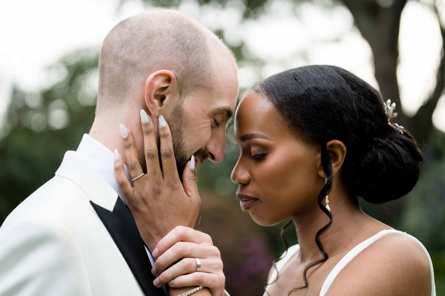 Romantic couple shares an intimate moment during outdoor photo session in nature.