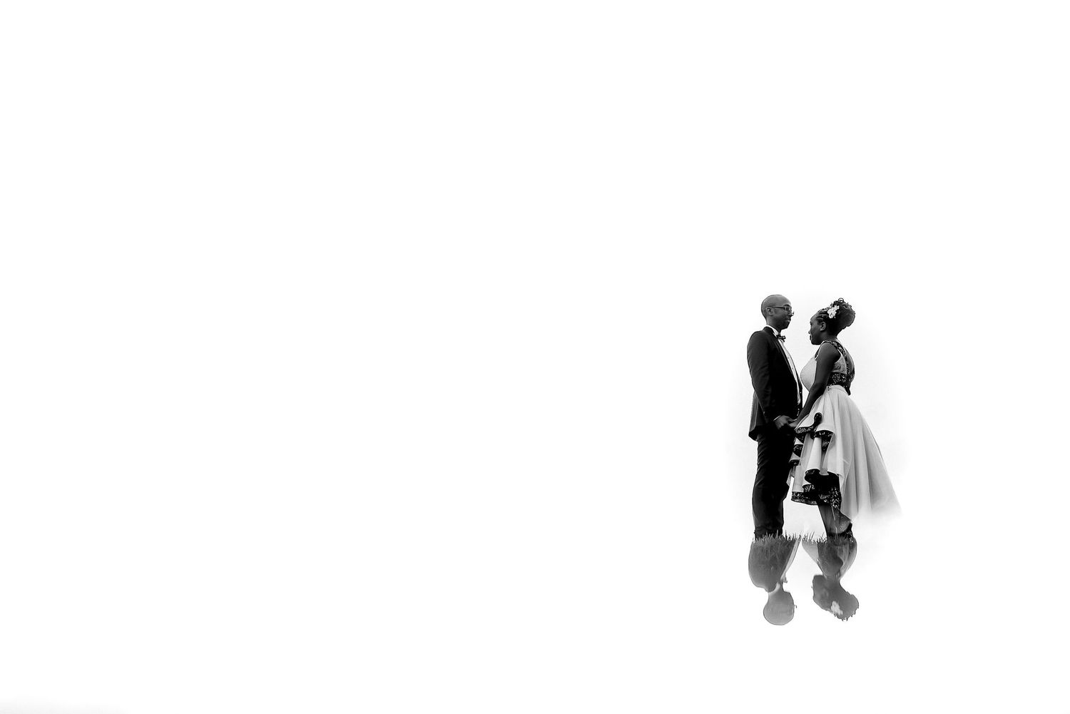 Minimalist black and white portrait of couple in wedding attire against white background.
