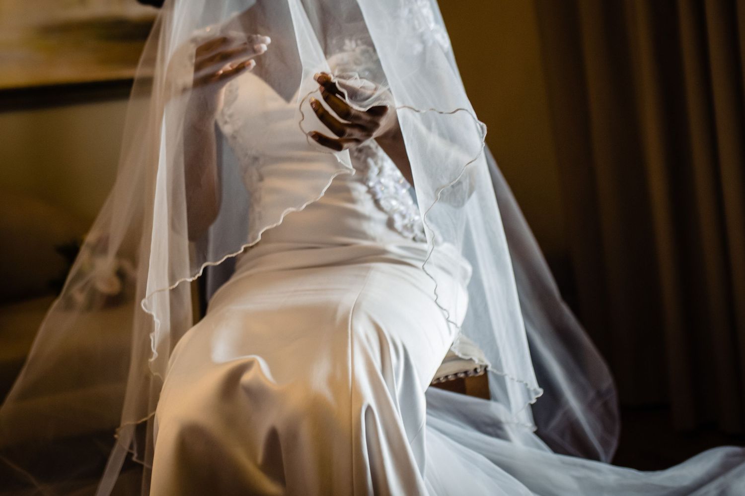 Close-up detail of white wedding dress fabric and veil.