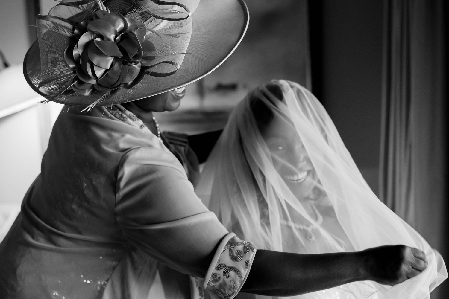 Detail shot of someone adjusting a wedding veil in black and white.