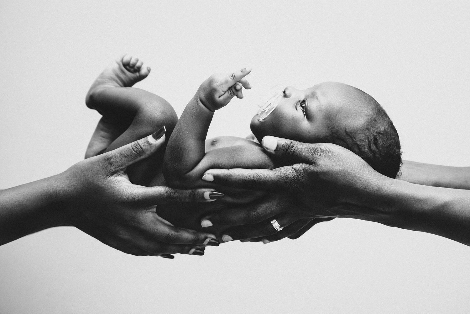 Minimalist black and white photo series capturing tender moments with newborn.