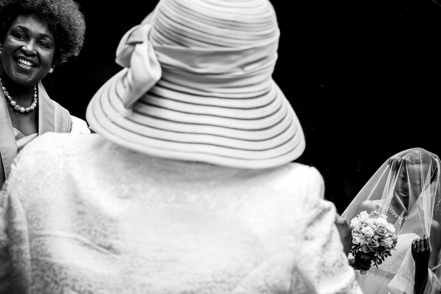 Artistic black and white composition featuring a white sun hat and wedding veil.
