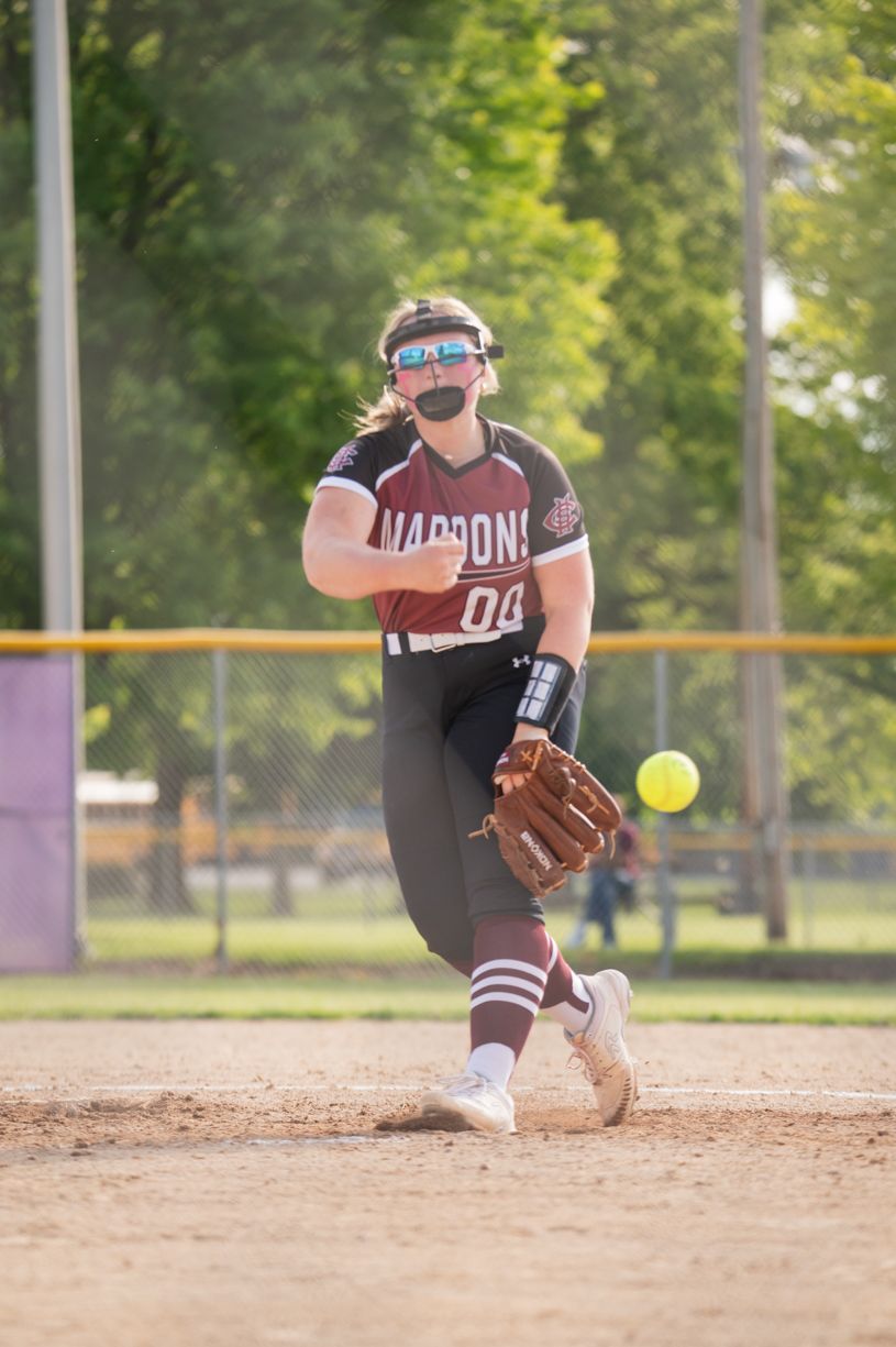 Softball player fields ground ball during practice on dirt infield.