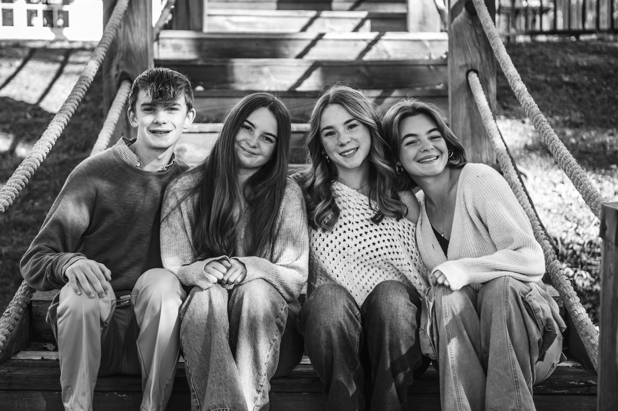 Candid moments shared on wooden deck during outdoor photoshoot.