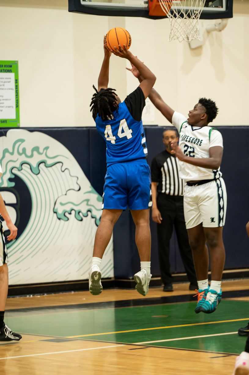 Two basketball players compete for the ball during intense game action.