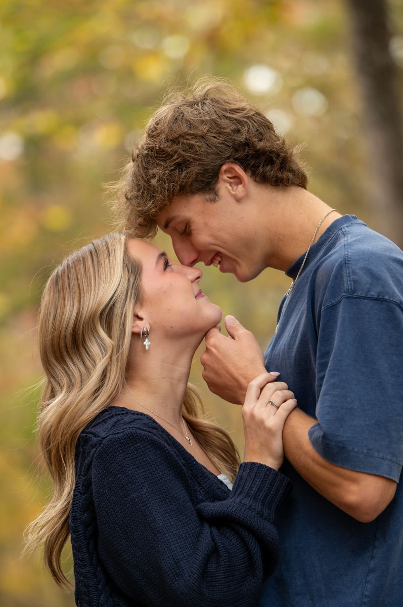 Romantic autumn couple photoshoot with fall foliage in background.