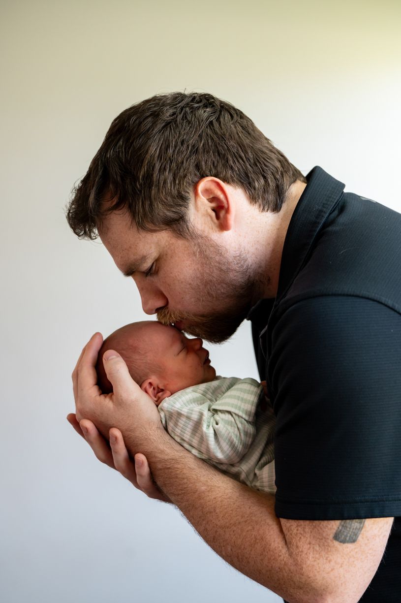 Tender moment between parent and newborn baby in intimate portrait.