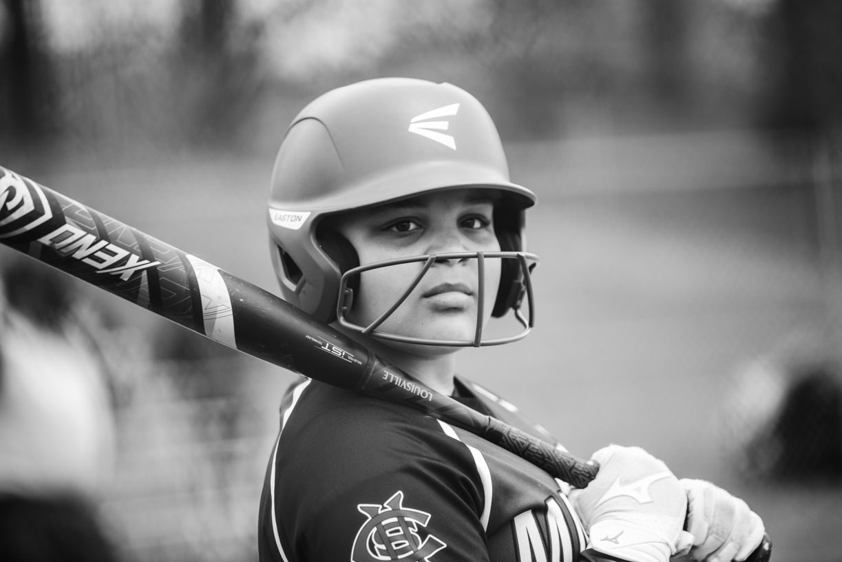 Softball player in action during competitive game sequence.