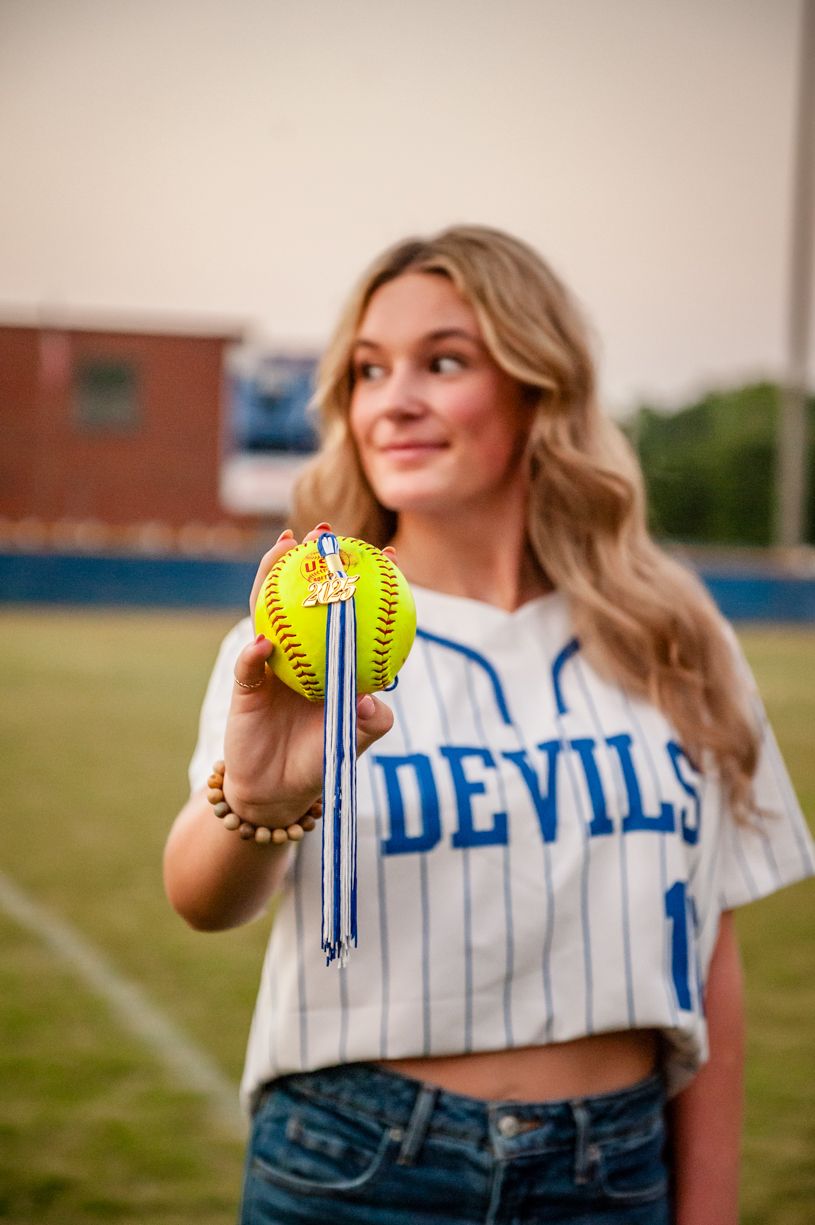 Senior softball player wearing a jersey showcasing softball and team uniform details.