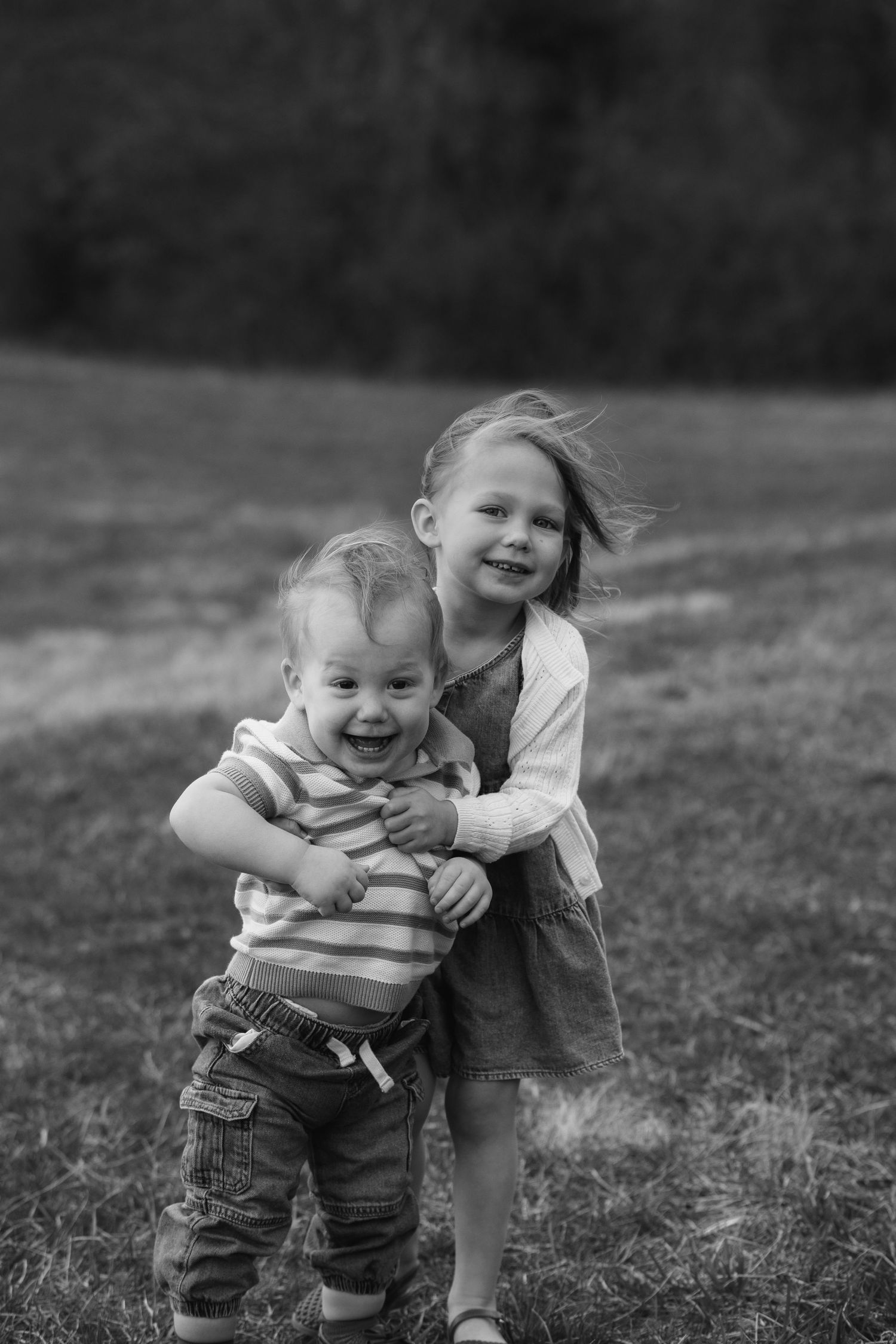 Black and white photo of playful moments in a grassy field.