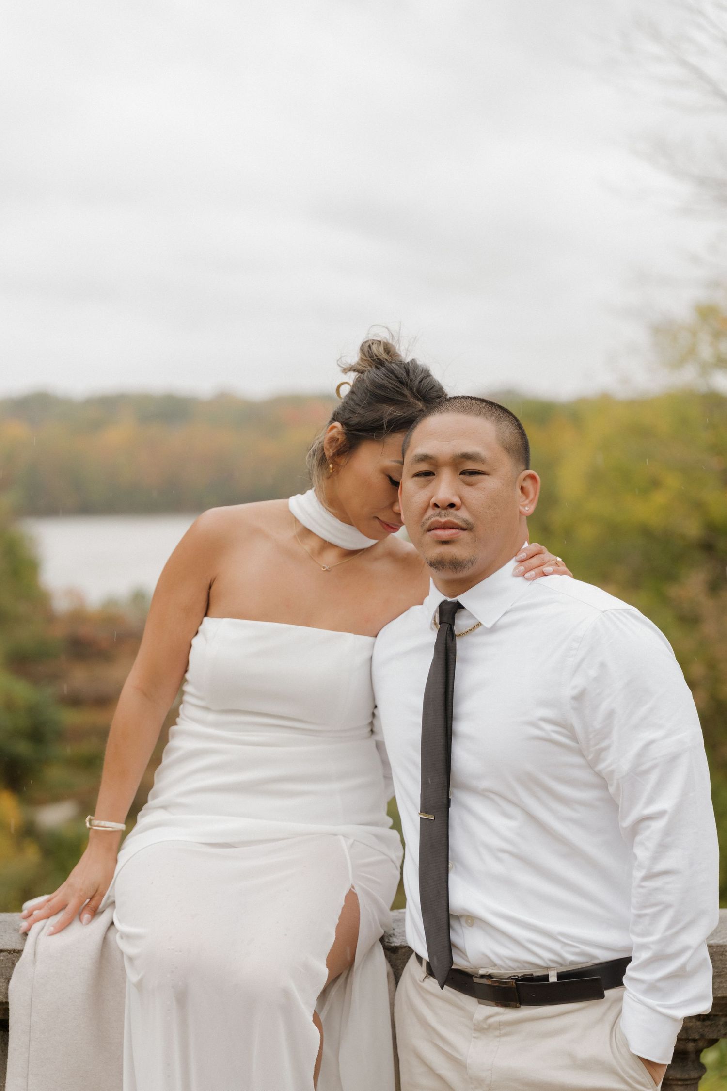 A romantic wedding portrait of a couple in formal attire against an autumn landscape with a lake in the background. new fields, indianapolis