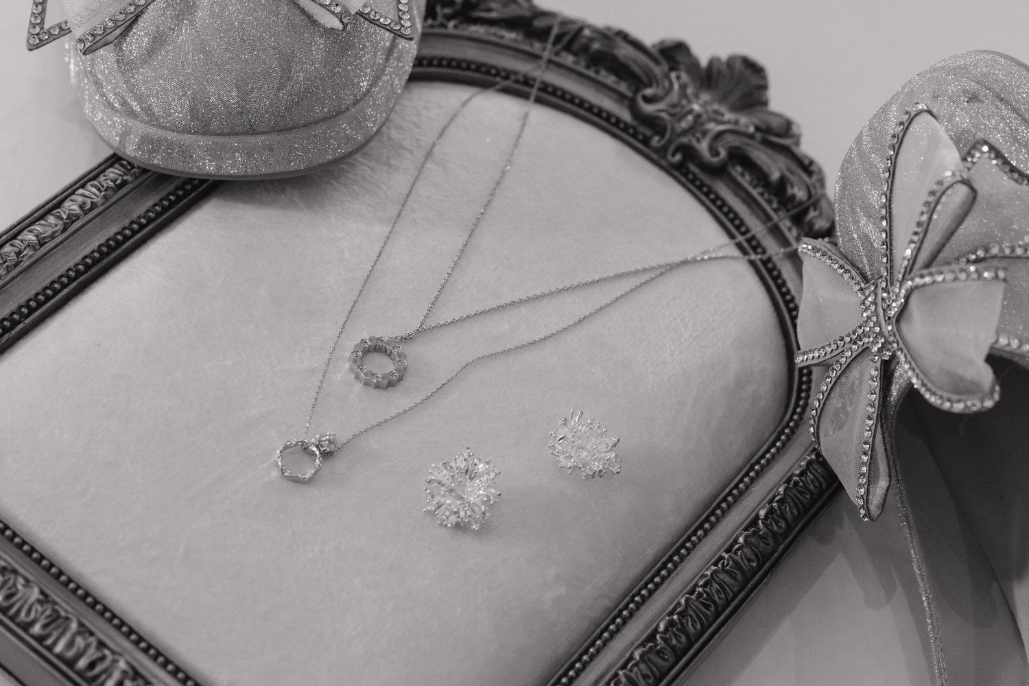Wedding jewelry and accessories displayed on ornate mirror in black and white. details for wedding