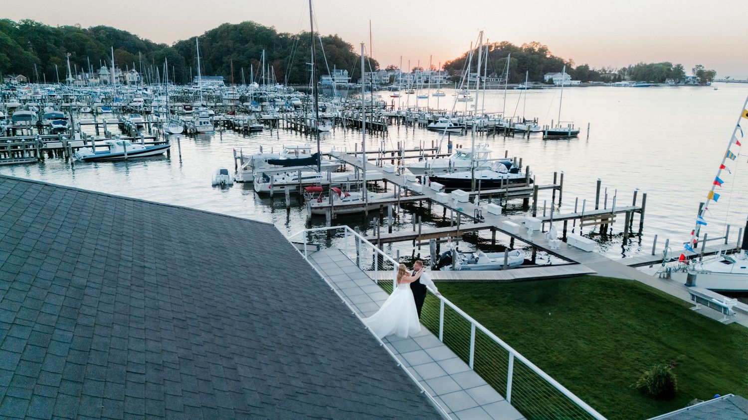 Panoramic view of a marina with boats docked at sunset showing multiple piers and docks.