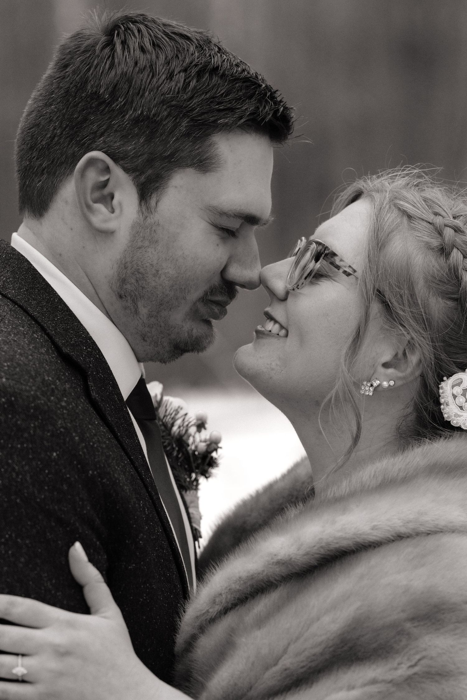 Black and white intimate wedding portrait with bride wearing fur wrap.