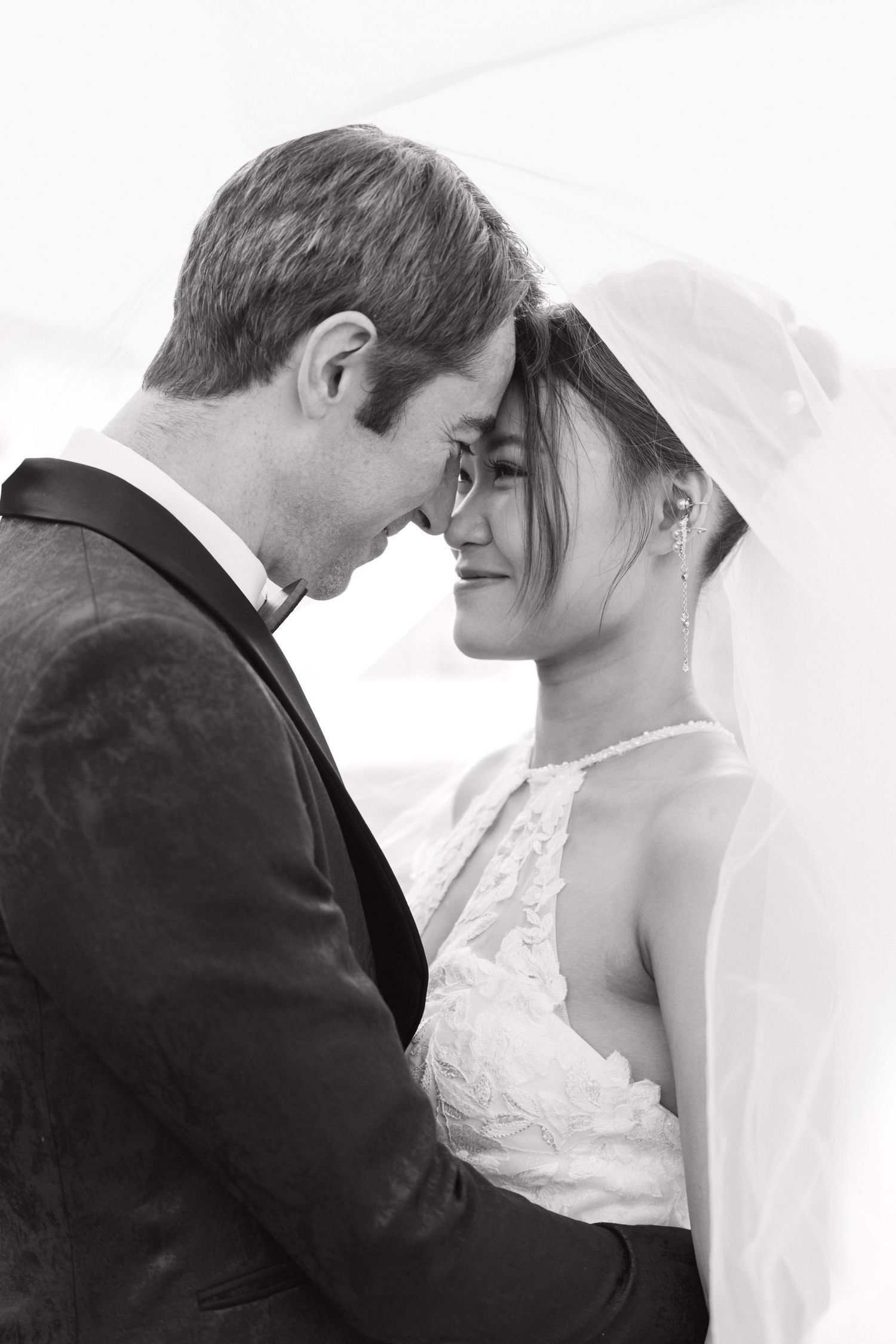 Intimate high-key wedding portrait in soft white tones.