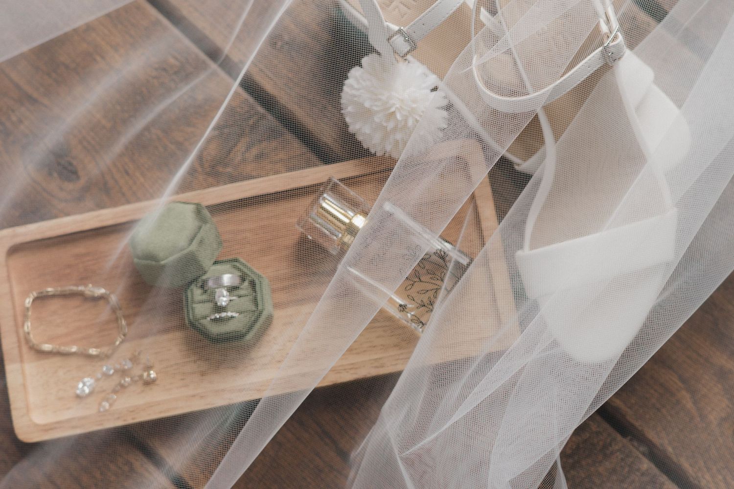 Wedding preparation details with delicate tulle veil and wooden accessories.