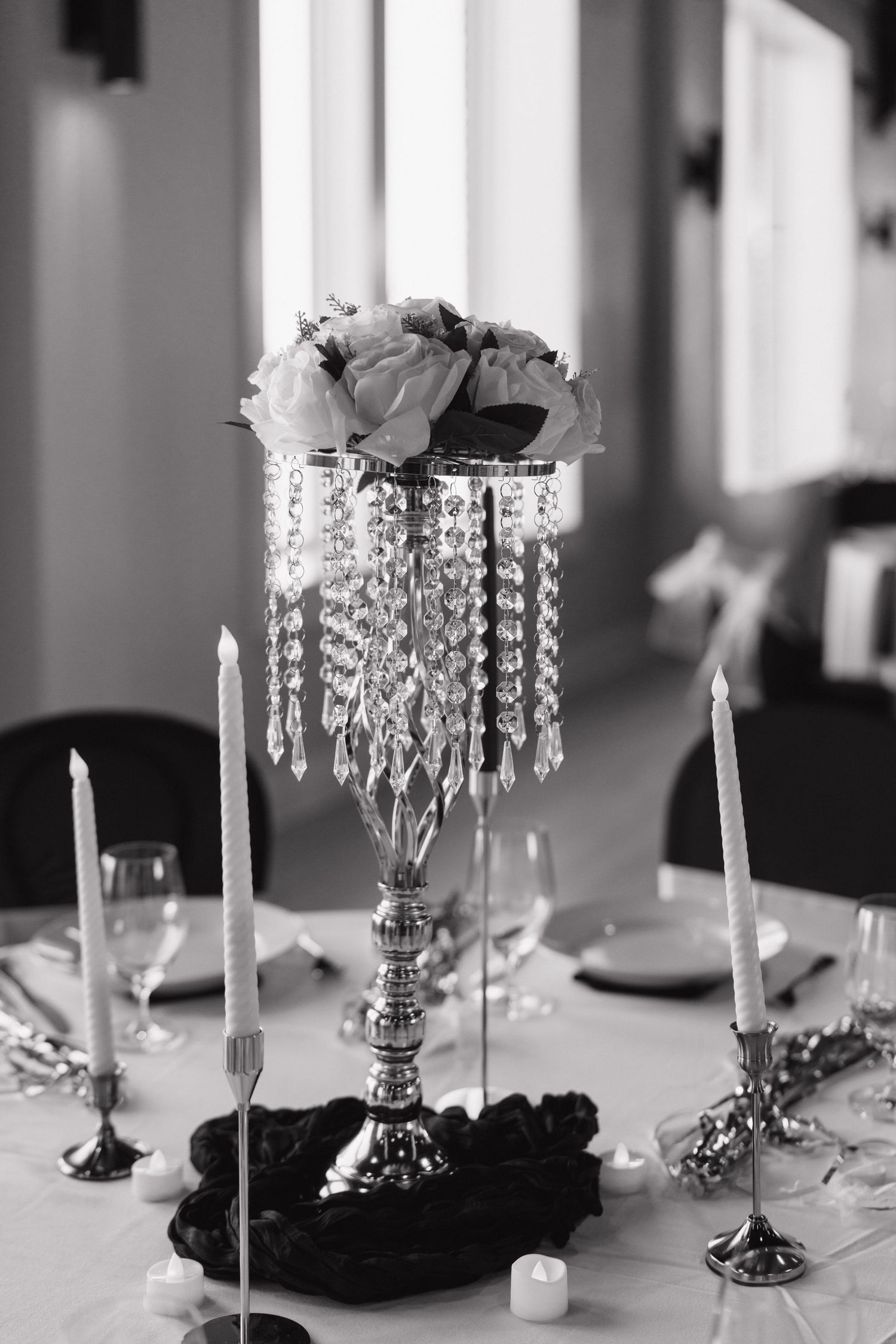 Elegant crystal centerpiece with white flowers and candles on formal dining table.details for wedding