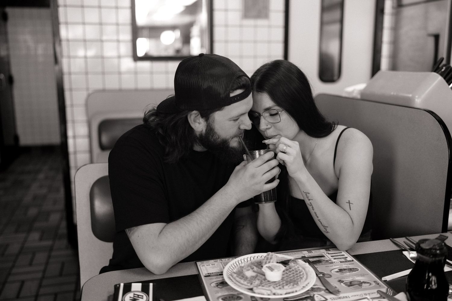 A series of black and white photos showing intimate moments of people in conversation at a restaurant or cafe.