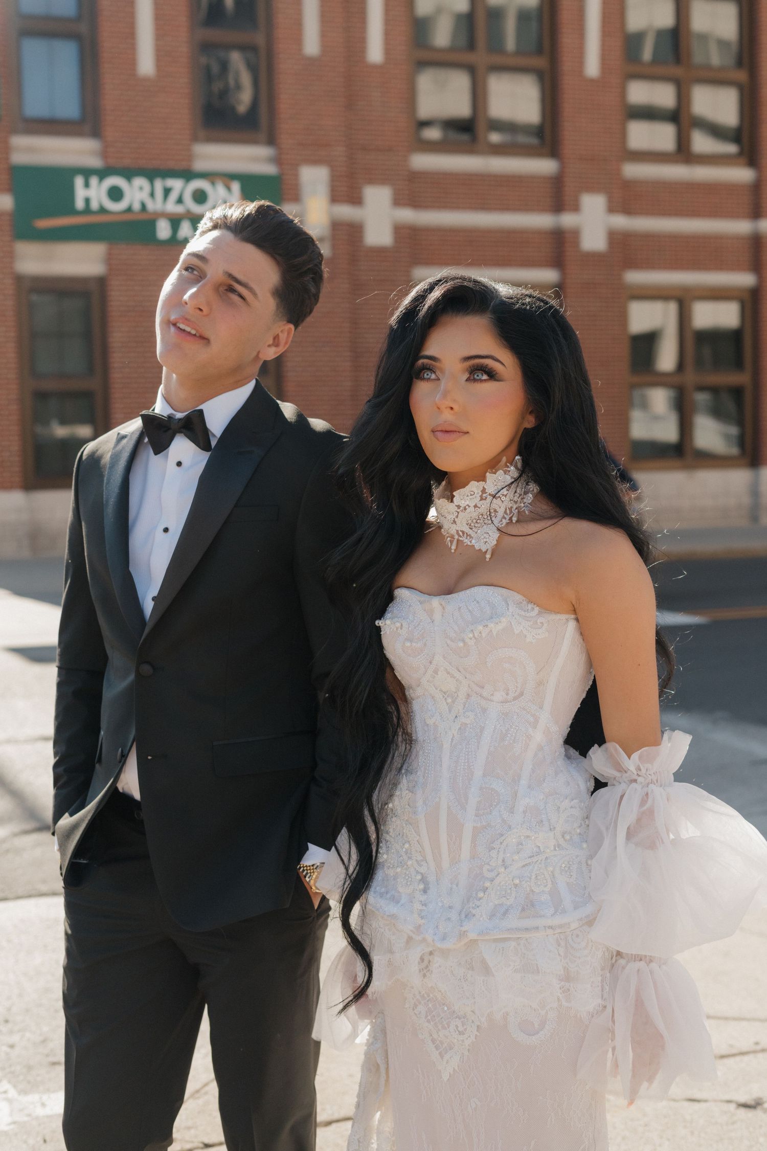 Wedding couple shares candid moments against urban backdrop.