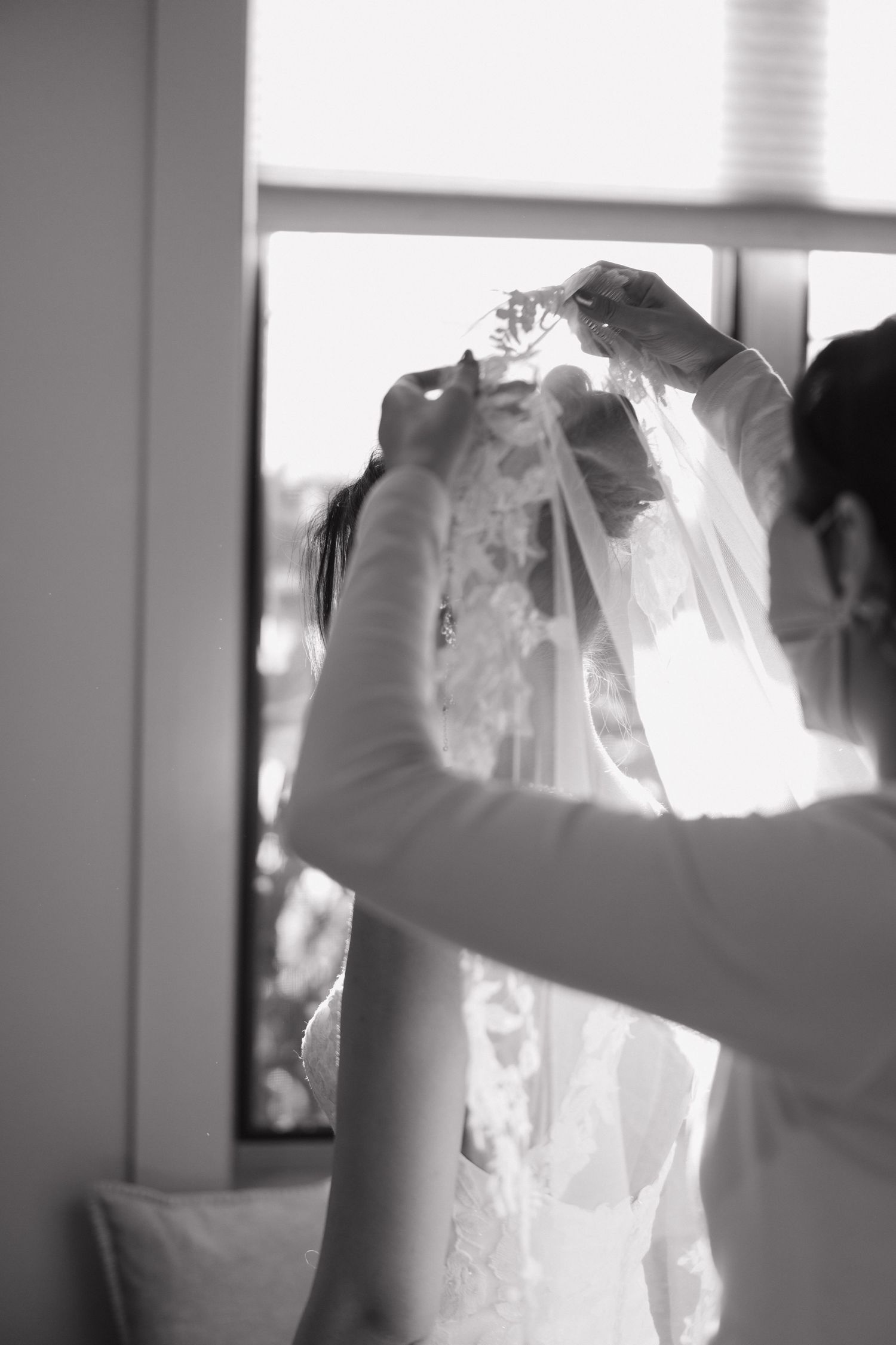 Series of images showing a wedding dress being held up in natural window light.
