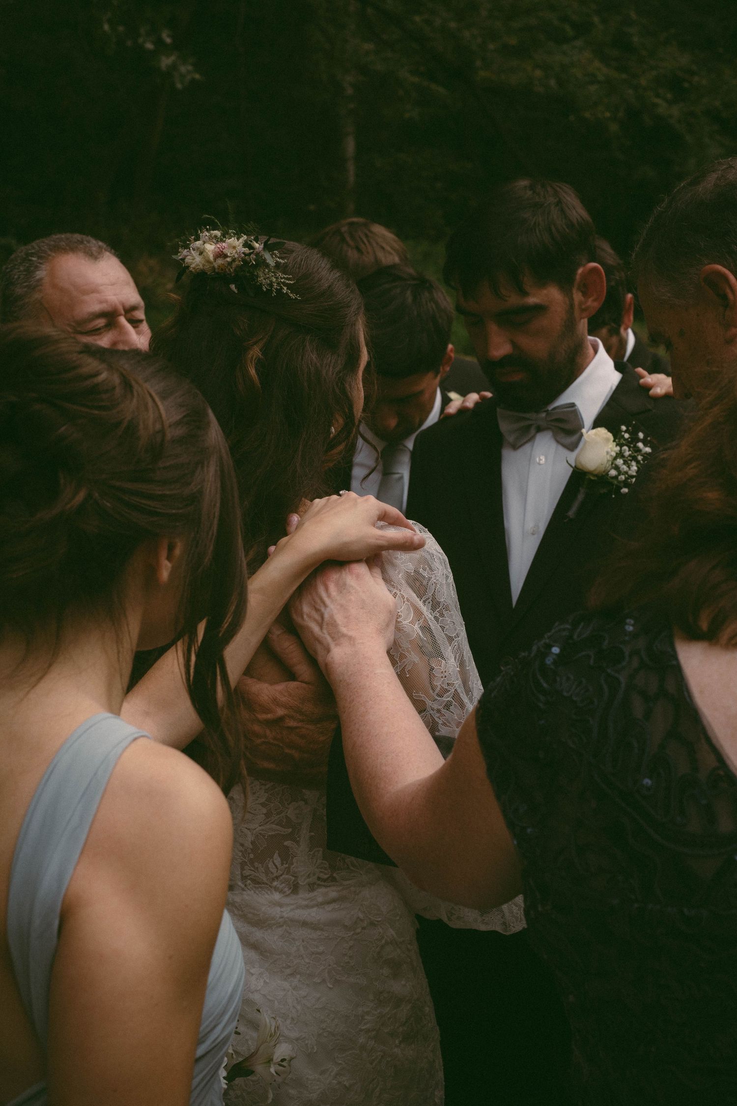Wedding guests gather around the newlyweds in an intimate moment during the celebration.