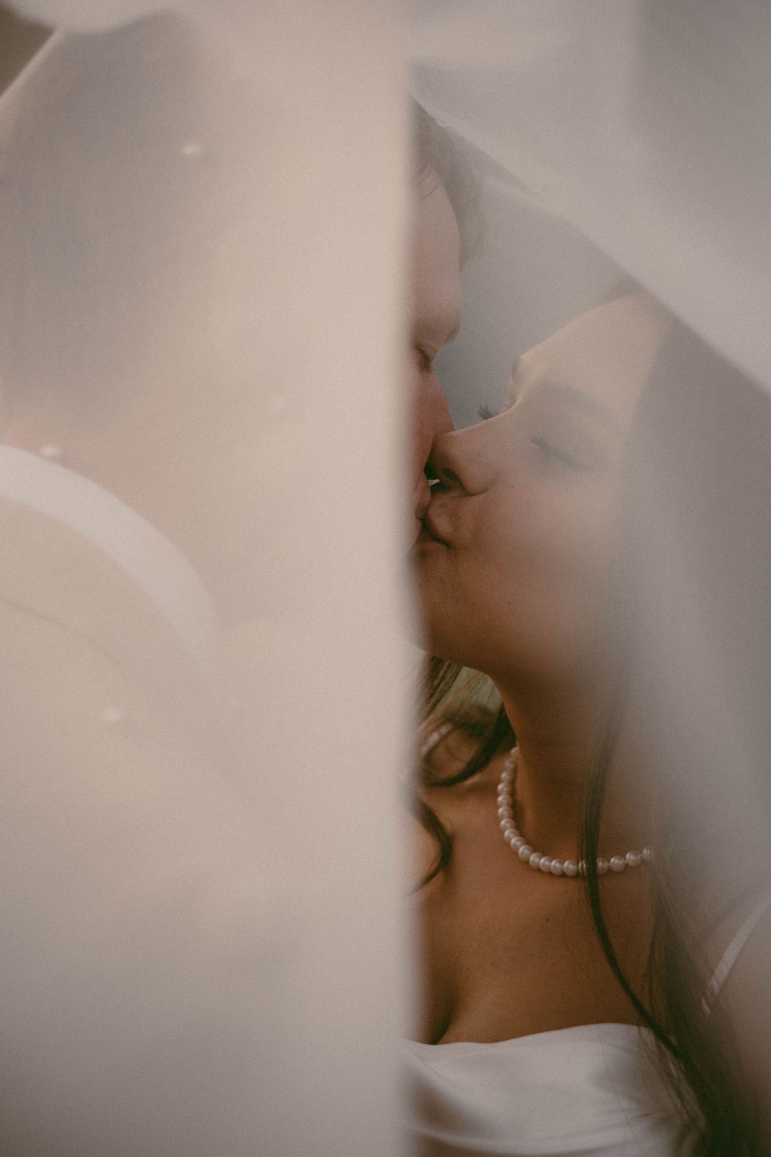 Dreamy portrait with soft focus and delicate pearl necklace details.