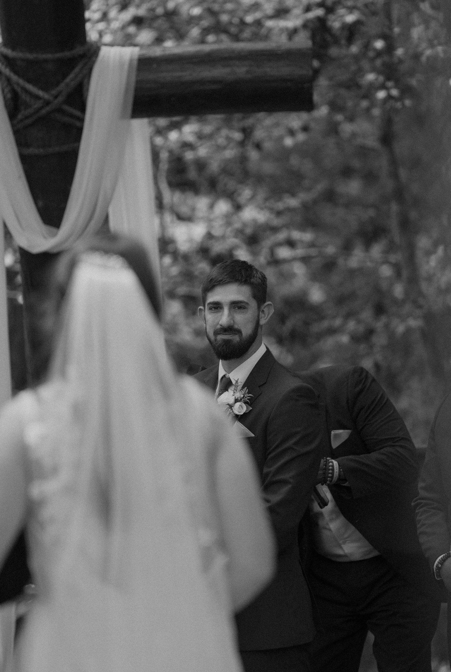 A black and white wedding ceremony moment captured through a veil.