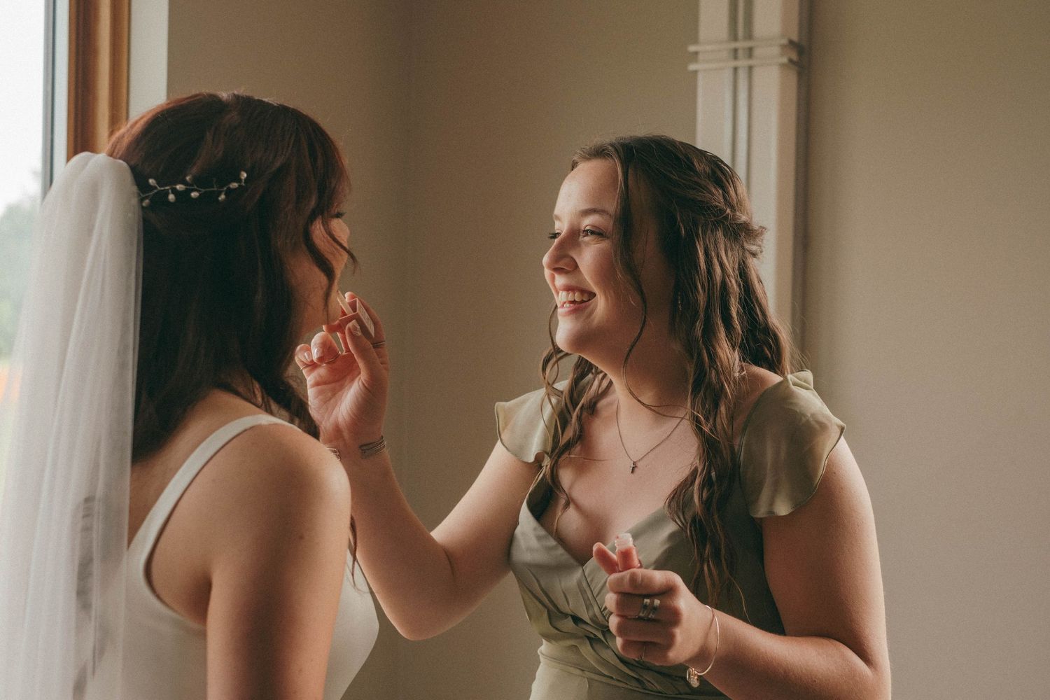 A quiet moment captured during wedding preparations in a sunlit room.
