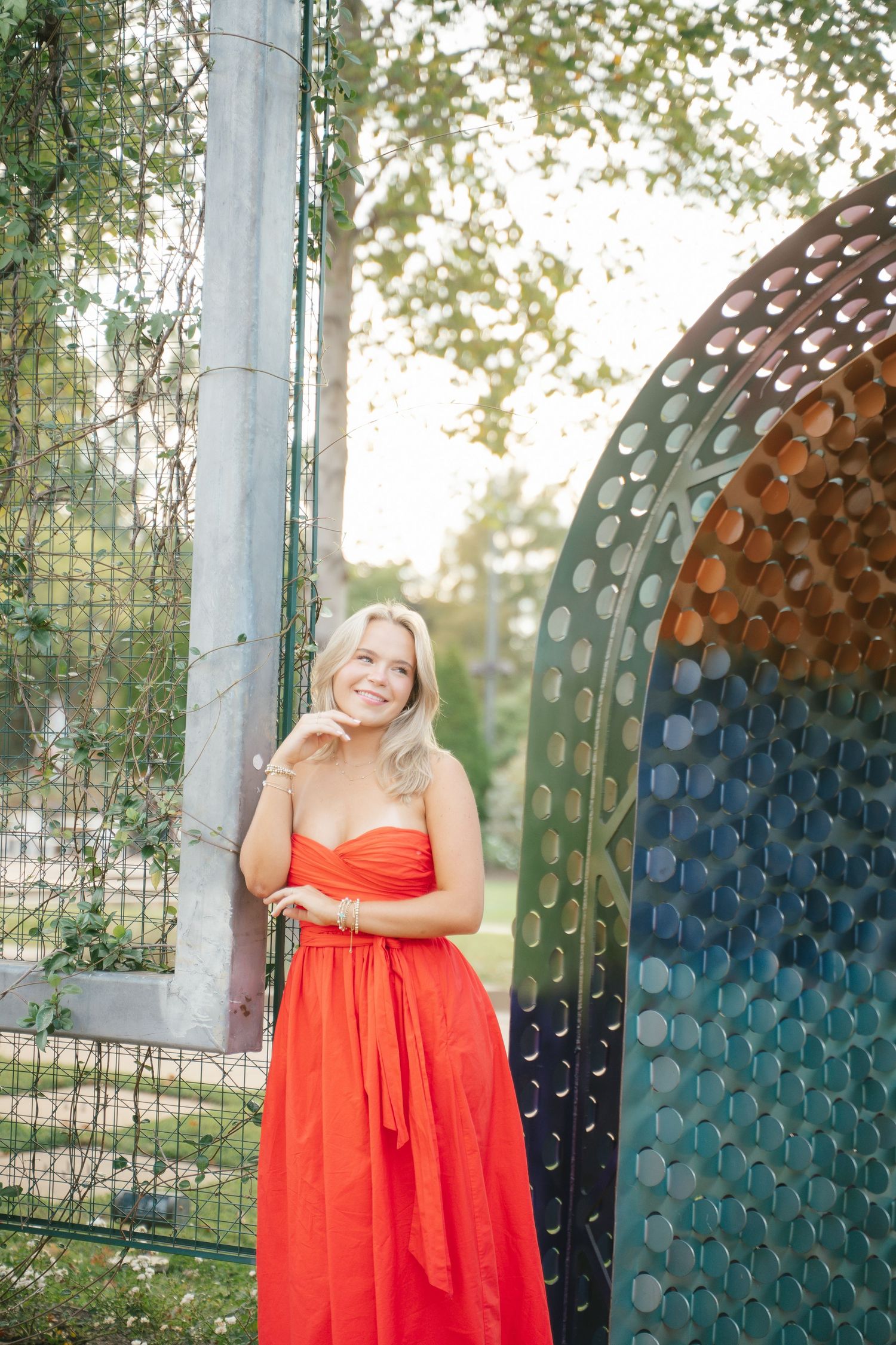 Portrait session against a colorful mosaic wall wearing a vibrant red dress.