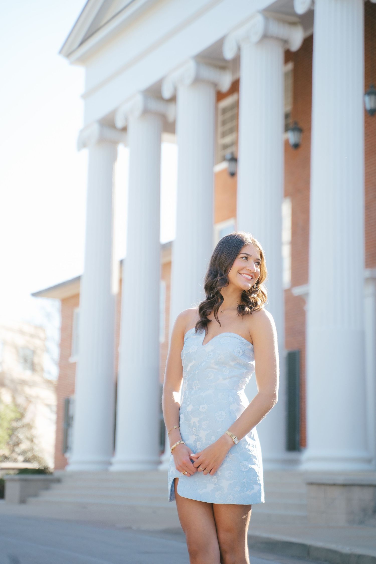 Elegant portrait session featuring white columns and classical architecture.