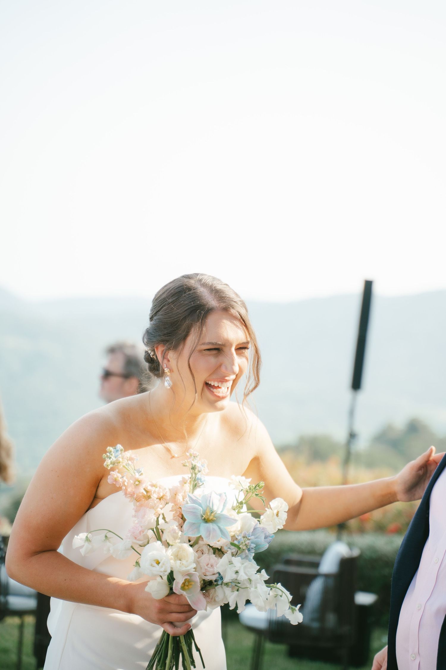 Candid wedding photography captures genuine laughter and emotions in natural sunlight.