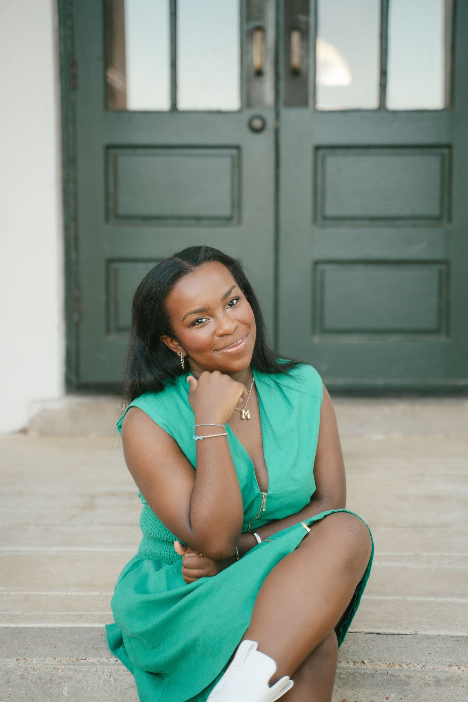 Summer fashion look with a green sleeveless dress photographed by a vintage door.