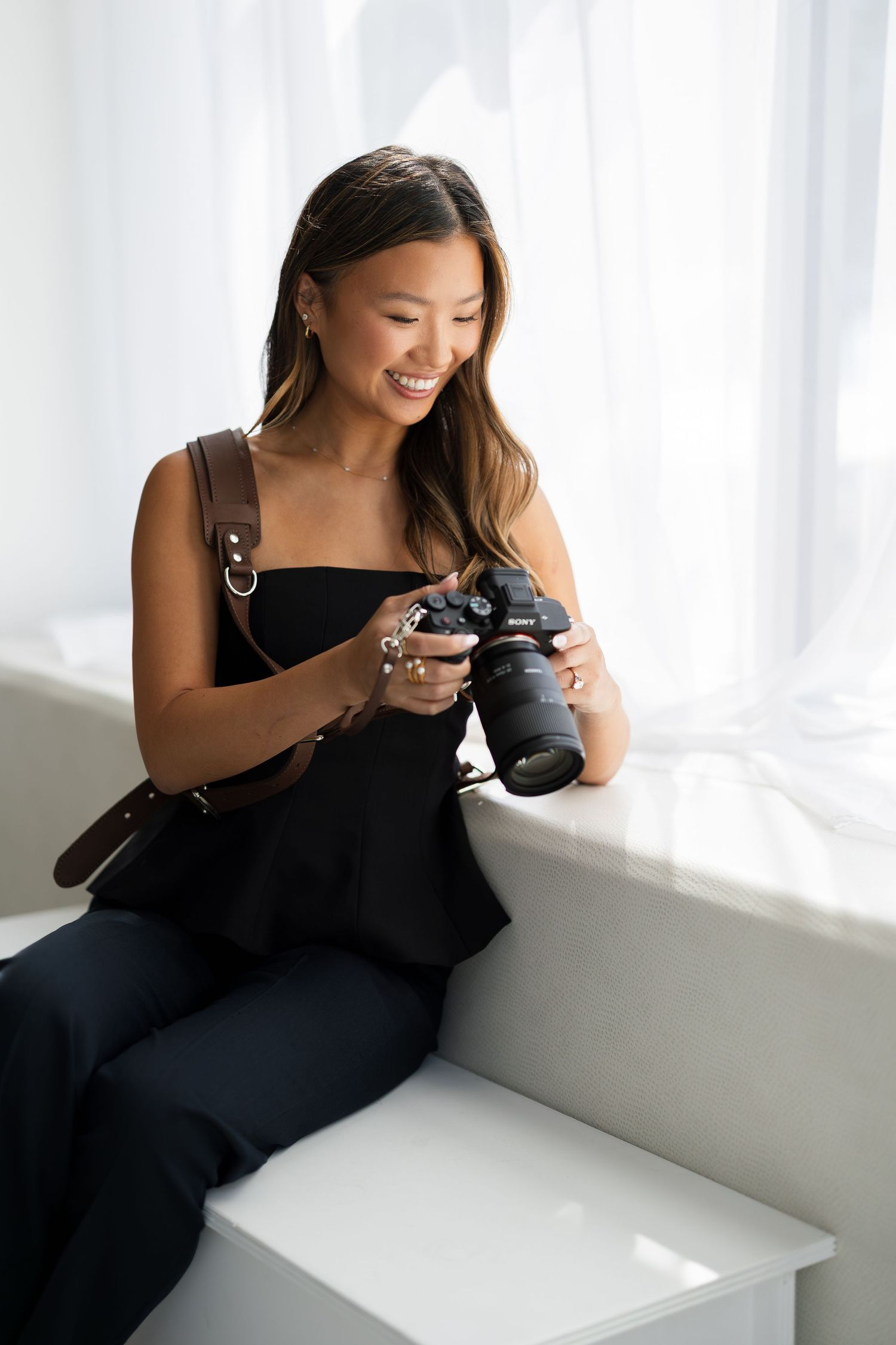 Professional photographer reviewing images on camera while lounging in studio.